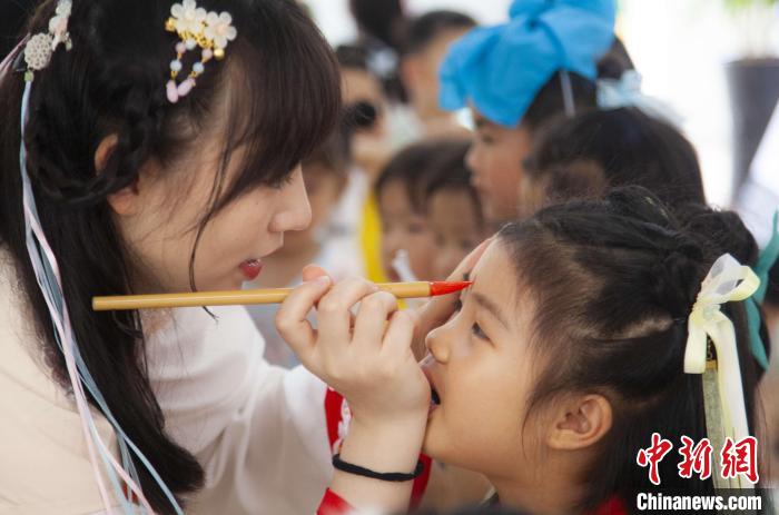 图为老师在孩子们额头上点上雄黄，驱邪辟祸。　董观生 摄