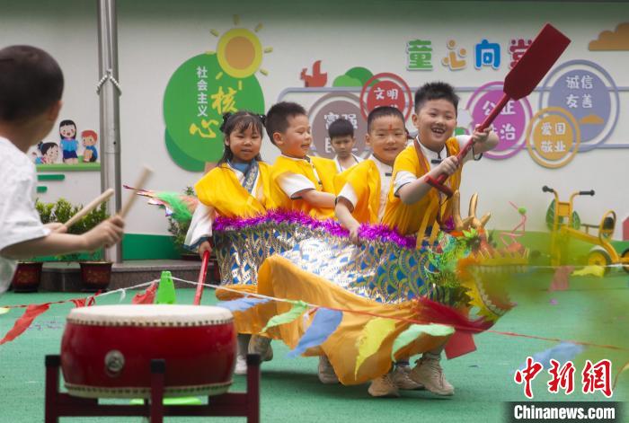 图为龙舟赛游戏上，小伙伴们打鼓加油。　董观生 摄