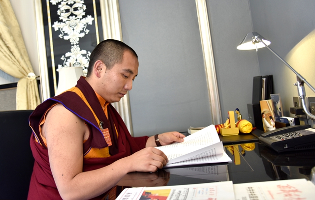 2图 1月9日，西藏自治区政协十一届二次会议间隙，琼布在驻地翻看会议资料。.jpg