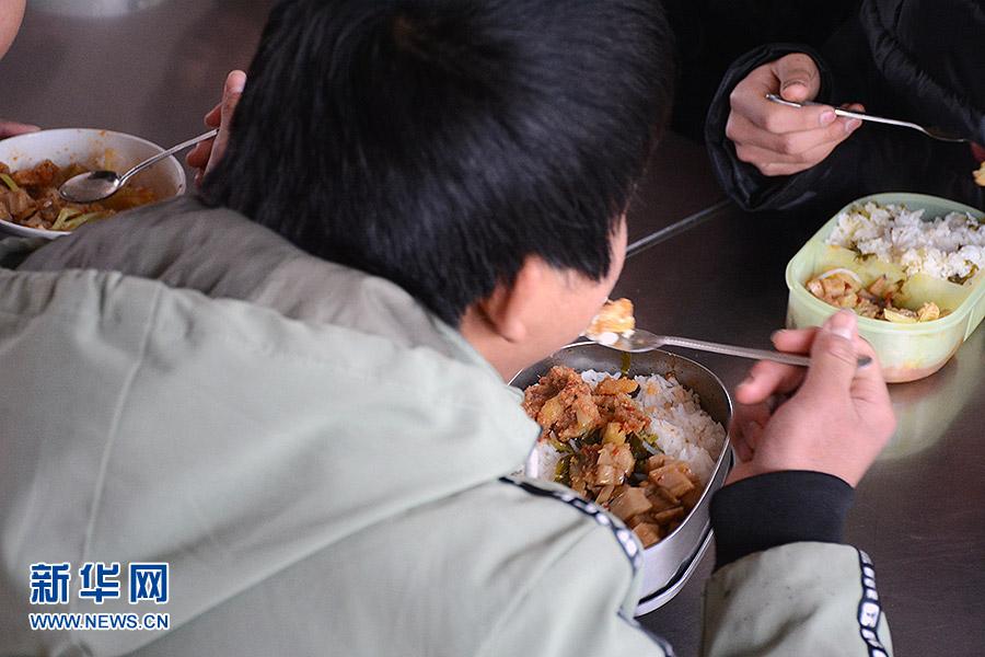 1月3日，重庆南川区北固中学的一名学生在食堂吃饭。当天学校的午餐食谱为：粉蒸肉、酥肉粉丝汤、炒花菜、炒莲藕。新华网赵紫东 摄