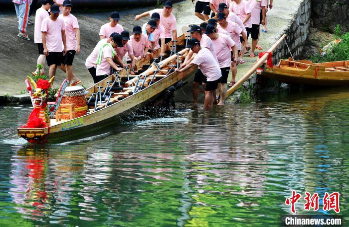 图为5月29日，长乐江田镇村民们齐力推新龙舟下水。　张斌 摄