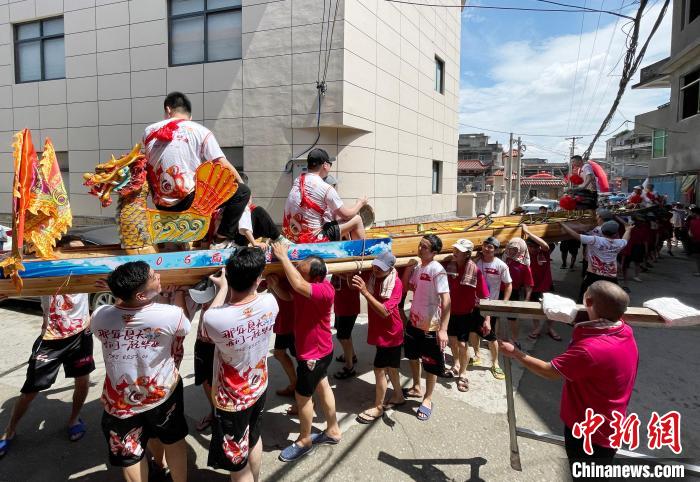 图为5月29日，长乐江田镇村民们肩扛着新龙舟举行入水前游街仪式。　张斌 摄
